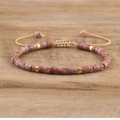 Close-up of adjustable imperial stone woven bracelet with golden spacer beads on wood - No.9 Sesame Red Jasper