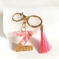 Detailed view of pink resin letter Z keychain with golden flakes and a soft tassel - Letter Z