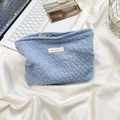 Détail de la trousse de maquillage bleu clair en seersucker au fini plissé doux - Bleu clair