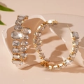 Close-up of golden C-shaped hoop earrings with emerald-cut crystals on stone background - Gold Rhinestone Circle (Silver Pin)