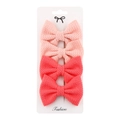 Detail of four peach pink fabric bow hair clips neatly arranged on a white card display - Two-tone Peach Pink