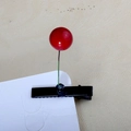 Detail of red berry hair clip with green wire on black duckbill clip and beige fabric - Cherry