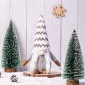 Gnomo di Natale nordico di peluche con cappello grigio e barba bianca su fondo di legno - Stile Donna