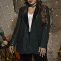 Detailopname van de donkergroene lovertjes blazer met zwarte fluwelen kraag bij model - XL / Donkergroen