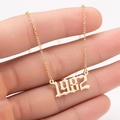 Detailed close-up of a golden gothic 1982 year necklace pendant held in hand - 1982 / Gold