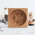 Square beechwood cookie mold featuring a carved circular floral and leaf pattern - Raspberry