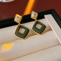 Dettaglio macro di orecchini a rombo dorati con intarsio verde e piccoli cristalli - Oro-Verde