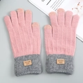 Pink and grey knit winter gloves with touchscreen fingertips and ribbed cuffs on grey surface - Pink