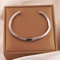 Gros plan sur un bracelet Möbius en acier inoxydable argenté sur coffret cadeau - Argent