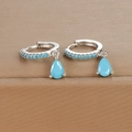 Macro detail of sky blue teardrop earrings with silver finish and crystal pave setting - Silver Blue Zirconia