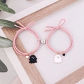 Pink magnetic couples bracelets with cartoon ghost enamel charms on white wood background - Pink Pair