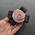 Close-up of handmade pink satin rose brooch with black ribbon bow and fine fabric texture - Ribbon Style / Pink