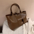 Braune gewebte PU-Leder Shopper-Tasche mit großer Kapazität und Schleifenverschluss auf Sofa - Braun