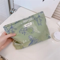 Dettaglio della borsa cosmetica in tessuto a fiori con etichetta simple wish - Verde