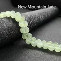 Macro detail of natural light green Shanshan jade beads with smooth polished texture - Xinschan Jade