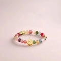Buntes Edelsteinarmband mit goldenem Münzanhänger auf weicher rosa Oberfläche - Bunter Stein Münze Stil (J1059)