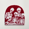 Detaillierte Textur der roten Strickmütze mit weißen Totenkopf-Jacquardmustern - Einheitsgröße / Rot