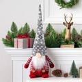 Detail of Christmas gnome plush doll with knit hat and white beard on a white mantel - Gray Hat Gnome Doll