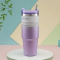 Close-up of a 30oz purple glitter vacuum insulated tumbler with lid and straw on a display - 30oz/890ml / Gradient Purple