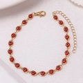 Detail van gouden koperen kettingarmband met rode Evil Eye-kralen en een handige karabijnsluiting - Goud Rood Armband