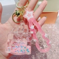 Close-up of pink liquid sandglass castle keychain with stars and metallic ring - Castle Pink