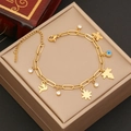 Detail eines vergoldeten Armbands mit Stern- und Vogelanhängern auf einer Schmuckbox - Strass Böses Auge Stil (9#)