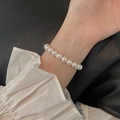 Elegant Aurora pearl bracelet in creamy white finish worn on wrist with black leather background - White 8mm Pearl Beaded (MY31512 8mm)