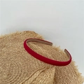 Detail of red fabric headband placed on a straw hat against a white wall background - Burgundy