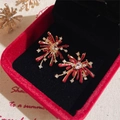 Detail of red firework stud earrings with crystals on a jewelry display case - Firework Shape (Red) / Red-Gold