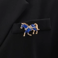 Dettaglio di spilla a cavallo in smalto blu con cristalli sul risvolto di un blazer - Blu