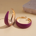 Close-up of geometric C-shaped earrings with purple matte finish and gold interior - Purple