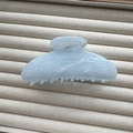 Detail of light blue marble textured hair claw clip on beige velvet display - Blue Semicircle 11cm