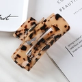 Detailed view of a 10cm tortoiseshell acetate hair claw clip on a white ceramic plate - 3# Beige 10cm Acetate Claw Clip