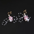 Detail view of golden leaf earrings with pink petals and white pearls on black background - Clip-On Earrings / Pink