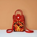 Close-up of red knitted phone bag with yellow chain pattern and silver magnetic buckle - Year of the Snake (Red)