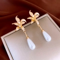 Detail of gold floral earrings with white teardrop pearls on a textured display card - 30# Silver Earring Post - Gold - Flower Drop (Real Gold Plated)