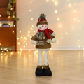 Detail of a standing Christmas snowman doll with red plaid hat on wooden floor - Snowman