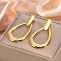 Detailed view of long gold drop earrings featuring a sleek oval hollow design on satin fabric - Large Hollow Waterdrop Hoop Earrings / 925 Silver Needle