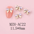 Macro detail of 11.5x8mm gold alloy bow nail art charm with purple gems on pink base - Gold Base Starry Pink (AC22)