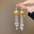 Detailansicht eleganter goldener Lotuspompon-Ohrringe mit weißen Perlen und glänzenden Zirkonia - Gold / Gold