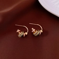 Detail of vintage C-shape gold earrings with colorful floral oil drip on brown fabric - Multi-Colored Rings Embellishment Style
