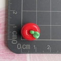 Detailansicht eines 1,2 cm großen Mini-Harzapfels mit grünem Blatt auf einer Skala - Mini 3D Roter Apfel