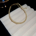 Vista detallada de una pulsera dorada de circonitas con cierre de mosquetón ajustable - Pulsera Redonda de Malla / Dorado