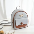 Compact grey and brown patchwork mini backpack for women featuring a gold bow detail - Gray