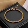 Elegante pulsera de malla dorada con detalles de anillos y cadena ajustable en caja - Pulsera