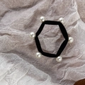 Dettaglio di un elastico per capelli con sei perle bianche disposte in forma esagonale - Nero