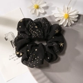 Elegant black mesh hair scrunchie featuring gold star patterns on a stylized gray tray - Black Gold Bronzing Star