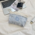 Primo piano della borsa cosmetica in velluto azzurro con ricami su fondo di stoffa bianca - Stile Jacquard a Cuore / Velluto Cuore Blu Chiaro