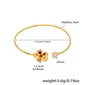 Macro shot of gold stainless steel bangle featuring zircon flower and starfish charm details - Gold Flower (Z428)