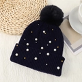 Dettaglio della trama in maglia del berretto blu navy con perle e grande pompon nero - Taglia unica / Blu Notte